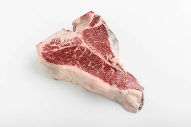 Beyaz arka planda bir parça taze t-bon çiftlik eti.