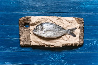 Akşam yemeğinde balık. Taze çiğ dorado balığı pişmeye hazır. Üst görünüm, düz uzanma