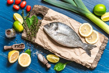 Akşam yemeğinde balık. Taze çiğ dorado balığı pişmeye hazır. Üst görünüm, düz uzanma