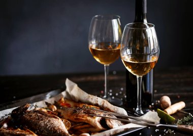 İki kişilik yemek konsepti. İki kadeh beyaz şarap, fırında balık..