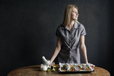 Şef kadın balık pişiriyor.