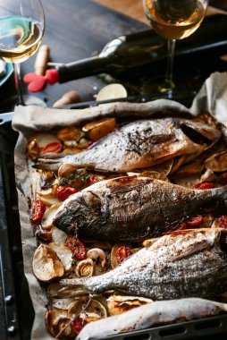 İki kişilik yemek konsepti. İki kadeh beyaz şarap, fırında balık..