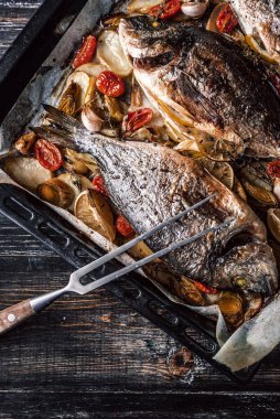 Annem tüm aile için yemek pişirir, dorado balığı pişirir.