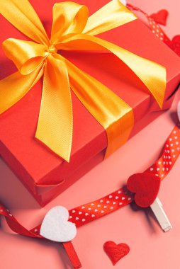 Kırmızı kutu altın kurdeleyle bağlanmış. Kurdele güzel bir fiyonk şeklinde bir kutuya bağlanmış. tatil hediyesi konsepti
