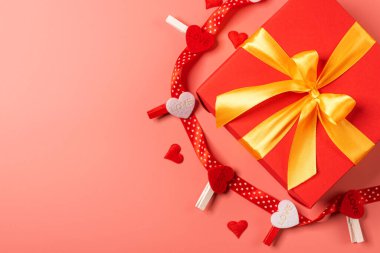 Kırmızı kutu altın kurdeleyle bağlanmış. Kurdele güzel bir fiyonk şeklinde bir kutuya bağlanmış. tatil hediyesi konsepti