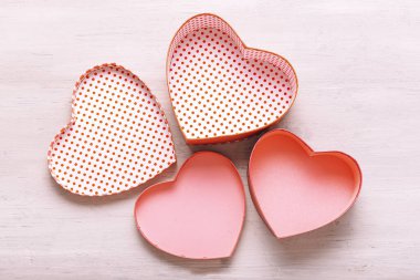 Sevgililer Günü konsepti. Kalp şeklinde hediye kutuları açık ahşap bir masada.