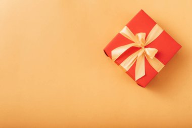 Kırmızı kutu altın kurdeleyle bağlanmış. Kurdele güzel bir fiyonk şeklinde bir kutuya bağlanmış. tatil hediyesi konsepti