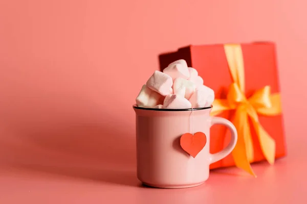 마시멜로가 분홍색 배경에 분홍색 머그잔은 모양으로 채워져 있습니다 옆에는 발렌타인데 — 스톡 사진