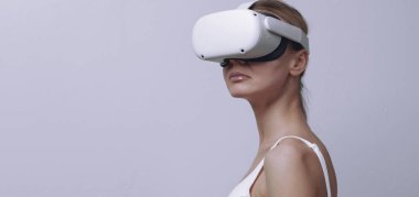 Kafasında video kaskı olan genç bir kadın arka planda.