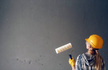 Kadın duvarı boyuyor.