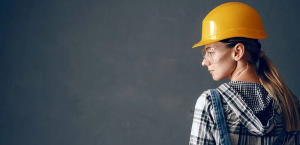 İnşaat alanındaki kadın mimar objeyi inceliyor.