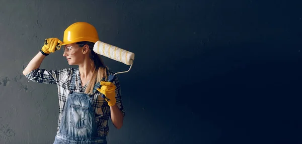 Kadın duvarı boyuyor.