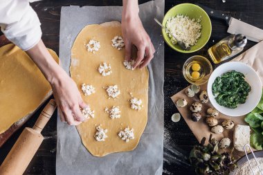 Aşçı adım adım ricotta peynirli ravioli, bıldırcın yumurtası ve baharatlı ıspanak hazırlar. Şef hamurun içini doldurur.