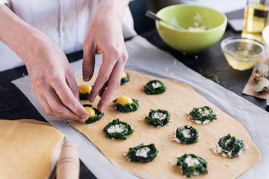 Aşçı adım adım ricotta peynirli ravioli, bıldırcın yumurtası ve baharatlı ıspanak hazırlar. Şef hamurun içini doldurur.