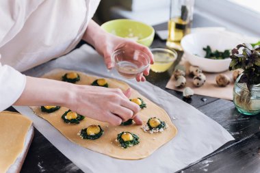 Aşçı adım adım ricotta peynirli ravioli, bıldırcın yumurtası ve baharatlı ıspanak hazırlar. Şef hamurun içini doldurur.