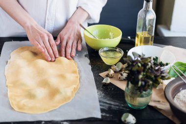 Aşçı adım adım ricotta peynirli ravioli, bıldırcın yumurtası ve baharatlı ıspanak hazırlar. Şef ravioli yapar.
