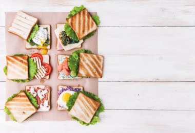 Altı sandviç ve farklı malzemeler.