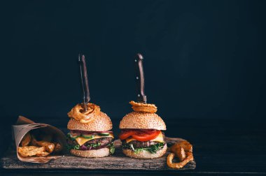 İki ağız sulandırıcı, nefis ev yapımı burger sığır eti doğramak için kullanılır. Tahta masada. Hamburgerler yerleştirilmiş bıçaklar..