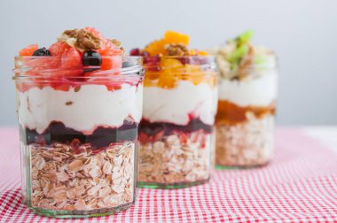 Cam kavanozda meyve ve mısır gevreği olan yulaf ezmesi.