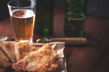 Ahşap bir arka planda biralı cheburekler. Börekler