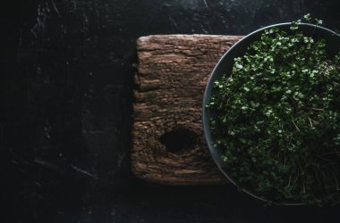 Ahşap bir arka planda gri bir çanakta mikroyeşil