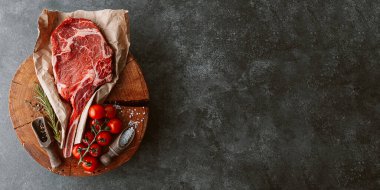 Taze çiğ kovboy baltası bifteği et için ahşap bir kesme tahtasının üzerinde
