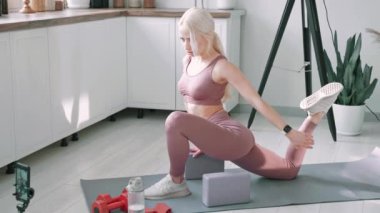 Online spor koçu konsepti. Genç beyaz kadın spor giyim koçu evde online derste bireysel antrenman yapıyor. Evde antrenman yapıyorum. Sağlık uygulaması ve sağlık konsepti