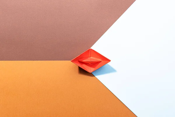 small red paper boat on a paper background. conceptual abstract image of the female genital organs of the vagina.
