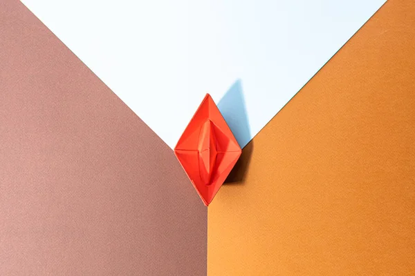 small red paper boat on a paper background. conceptual abstract image of the female genital organs of the vagina.