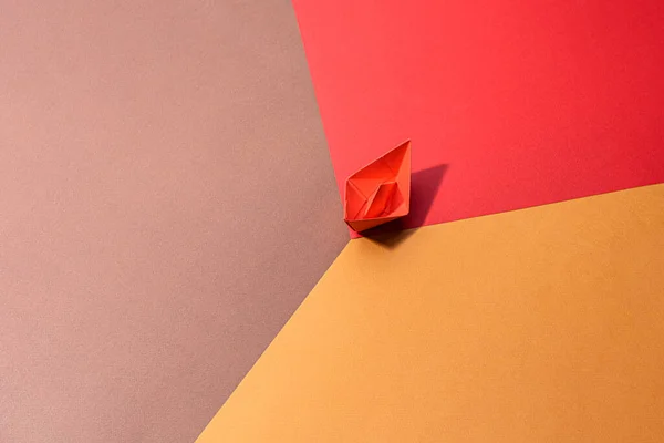 small red paper boat on a paper background. conceptual abstract image of the female genital organs of the vagina.