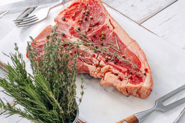 Beyaz ahşap arka planda taze ve çiğ biftek.