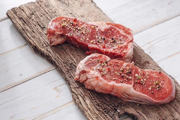 Čerstvý Syrový Striploin Steak Bílé Dřevěné Desce Dřevěném Pozadí Solí — Stock fotografie