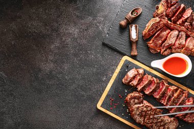 İki biftek striploin ve t-bon, orta pişmiş, taş bir arka planda. İki kişilik akşam yemeği.
