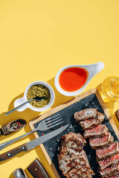 two strip steaks in medium rare fried on a yellow background. dinner concept for two