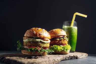 Glütensiz ve etsiz iki taze vejetaryen burger. Gri taştan bir arka planda hamburger. Lokantada ya da kafede hamburger servis ediyorlar.