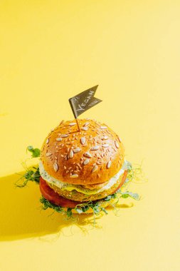 Glütensiz ve etsiz taze vejetaryen burger. Sarı arkaplanda hamburger