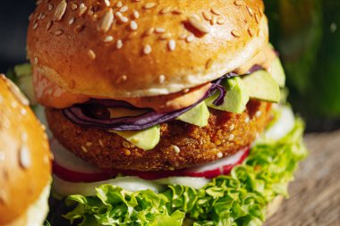 Glütensiz ve etsiz iki taze vejetaryen burger. Gri taştan bir arka planda hamburger. Lokantada ya da kafede hamburger servis ediyorlar.