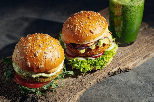 two bright fresh veggie burger without gluten and meat. burger on a gray stone background. serving burgers in a cafe or restaurant