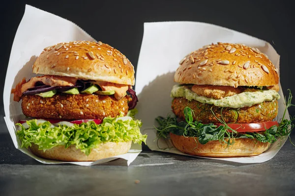 two bright fresh veggie burger without gluten and meat. burger on a gray stone background. serving burgers in a cafe or restaurant