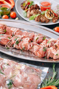 Barbekü için marine edilmiş et. Vakumlanmış ve marine edilmiş et, şişte et ve tabakta soslu ızgara et.