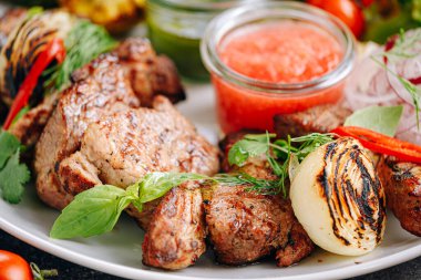 Şiş kebap ve sebze ızgara ve beyaz tabakta servis edilir.