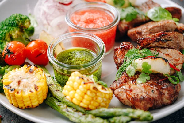 Şiş kebap ve sebze ızgara ve beyaz tabakta servis edilir.