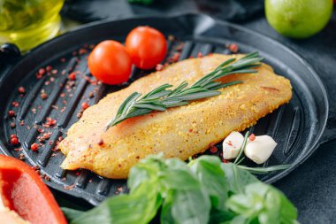 Baharatlı ve zeytinyağlı çiğ hindi filetosu, ızgaraya hazır.