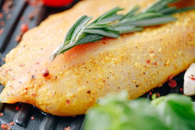 Baharatlı ve zeytinyağlı çiğ hindi filetosu, ızgaraya hazır.