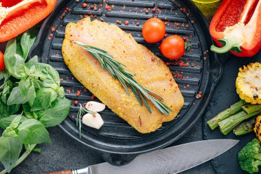 Baharatlı ve zeytinyağlı çiğ hindi filetosu, ızgaraya hazır.