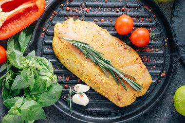 Baharatlı ve zeytinyağlı çiğ hindi filetosu, ızgaraya hazır.