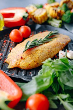 Baharatlı ve zeytinyağlı çiğ hindi filetosu, ızgaraya hazır.