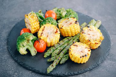 Kızarmış sebze, mısır, domates, brokoli ve kuşkonmaz.