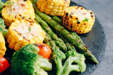 Kızarmış sebze, mısır, domates, brokoli ve kuşkonmaz.