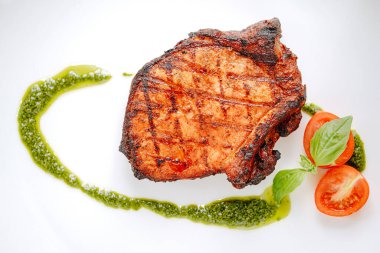 Baharatlı kızarmış domuz eti, zeytinyağı ve fesleğen sosu.